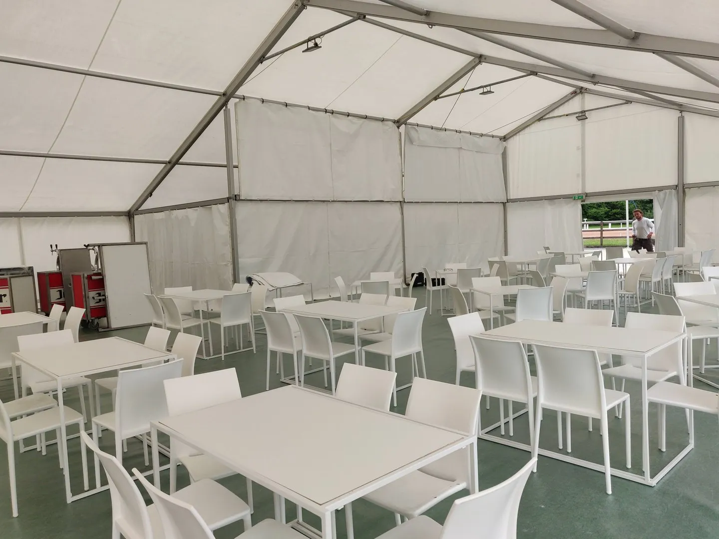 Tables et chaises blanches sous un chapiteau